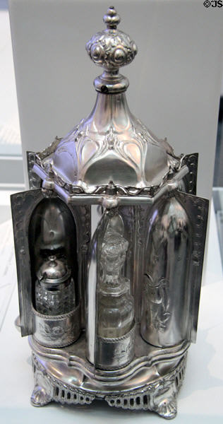 Magic Dinner Caster (c1860) wherein turning a knob reveals condiment bottles by Roswell Gleason & Sons of Dorchester, MA at Brooklyn Museum. Brooklyn, NY.