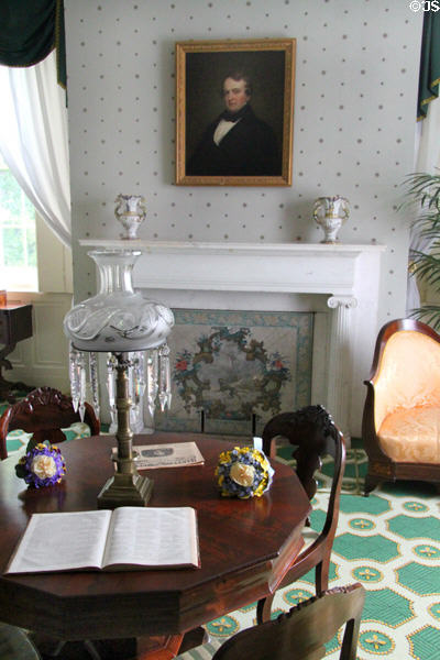 Pedestal center table (1835-45) with brass sinumbra lamp with glass shade & prisms (1835-45) in front of sitting room fireplace with wallpaper-covered fireboard (c1840) at Lindenwald. Kinderhook, NY.