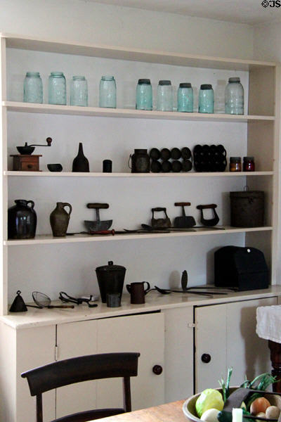 Kitchen shelving with glass canning jars, molds, round bladed chopping knives & other utensils at Lindenwald. Kinderhook, NY.