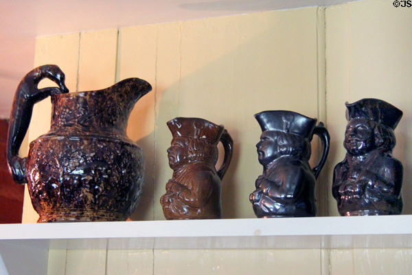 Brown salt glaze embossed pitcher with wolf shaped handle & Toby jugs at Home Sweet Home Museum. East Hampton, NY.