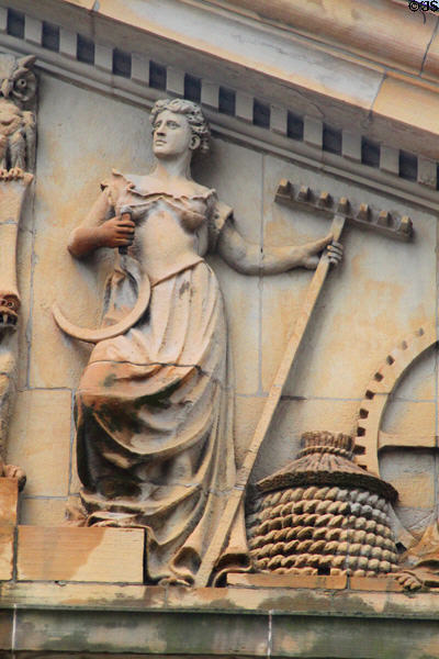 Pediment of Stark County Courthouse with detail of female with sickle, rake and beehive. Canton, OH.