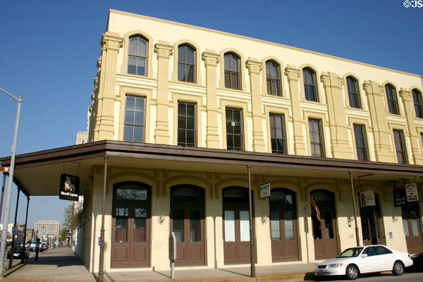 Brown Victorian building with covered sidewalk (306 Kempner). Galveston, TX.