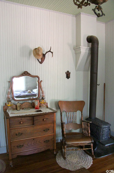 Bedroom with dresser, rocking chair & heating stove at Sauer-Beckmann Farmstead. Stonewall, TX.