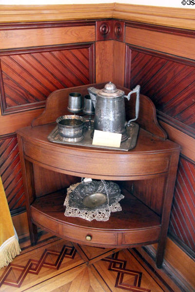 Corner étagère with metal water pitcher & basket tray at Capt. Charles Schreiner Mansion. Kerrville, TX.