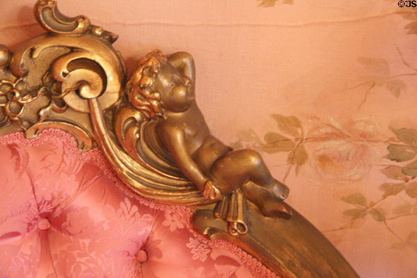 Detail of decorative gilt cupid carving on sofa in pink parlor at McFaddin-Ward House. Beaumont, TX.