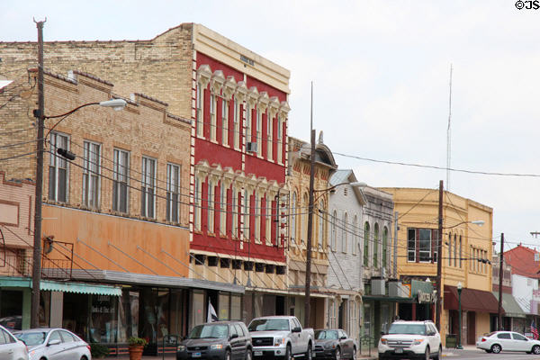 Commercial heritage streetscape (N Saint Joseph St.) including red Masonic building (1881). Gonzales, TX.