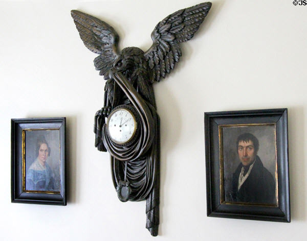 Pine carved eagle with clock imbedded & bearing the name of the clockmaker Joseph Neeg of Munich (c1750) framed by portraits of Wilhelm & Caroline Trundt Brueckish at Museum of Texas Handmade Furniture. New Braunfels, TX.