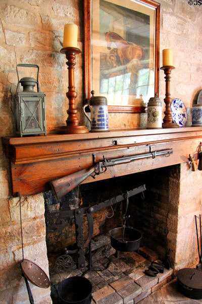 Family room fireplace built using stones of original cellar with black powder rifle which belonged on one of original New Braunfels settlers at Museum of Texas Handmade Furniture. New Braunfels, TX.