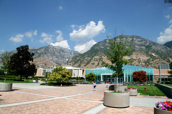 Campus setting of Brigham Young University beside mountains over green Harold B. Lee Library (1999) & Franklin S. Harris Fine Arts Center (1961). Provo, UT.