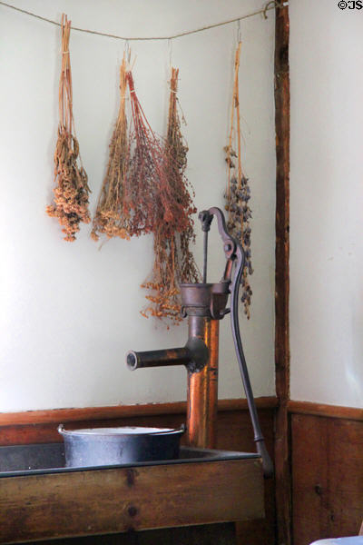 Herbs hung over metal water pump in kitchen in birthplace house at President Calvin Coolidge State Historic Park. Plymouth Notch, VT.