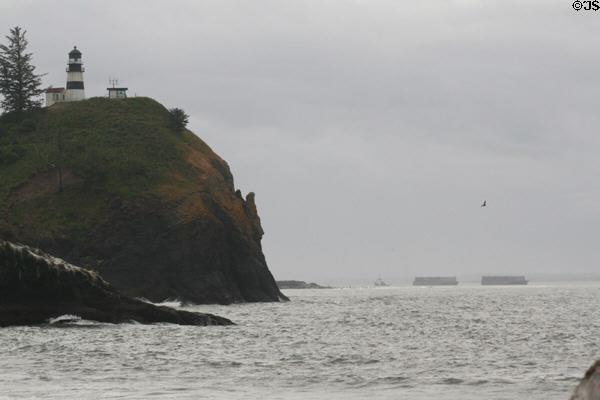 Ships pass Cape Disappointment Lighthouse to enter mouth of Columbia River. Ilwaco, WA.