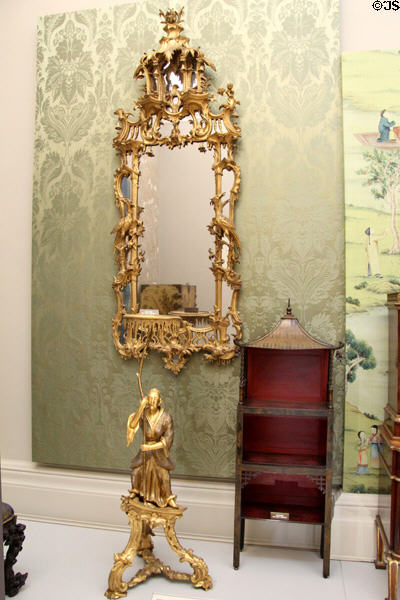 Chinoiserie pier glass (narrow mirror made to hang between two windows) (c1755) over Chinese figure torchère (portable lighting) (c1760) (possibly German) at Lady Lever Art Gallery. Liverpool, England.