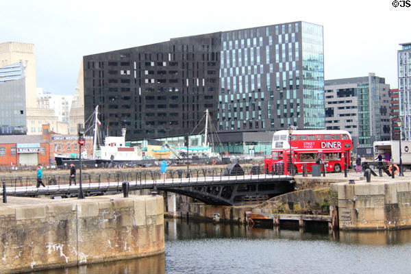 Heritage double decker bus converted to diner with new highrises surrounding Liverpool port attractions. Liverpool, England.