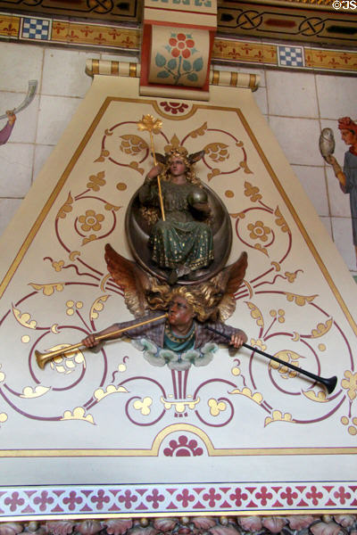 Painted stone chimneypiece with the figure of Fame & her herald holding two trumpets representing "great renown" or "ill fame" carved by sculptor, Thomas Nicholls in Day Nursery at Cardiff Castle. Cardiff, Wales.