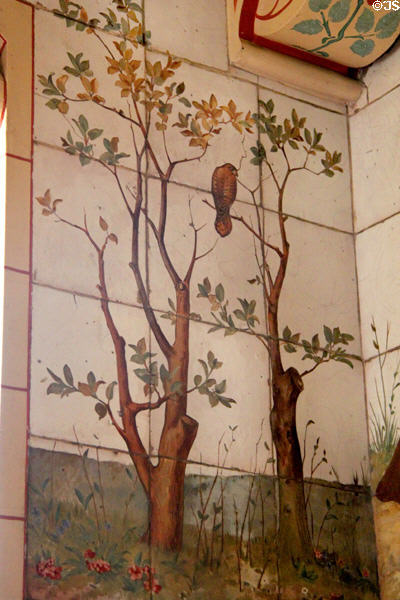 Invisible man outlined by tree branches holding hawk on painted tile work in Day Nursery at Cardiff Castle. Cardiff, Wales.