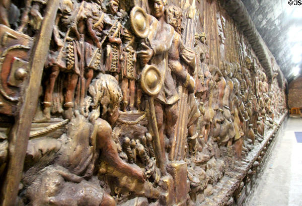 Roman Invasion of South Wales sculpted mural (1983) of cement & plaster finished in metallic gold paint by Frank Abraham at Cardiff Castle,. Cardiff, Wales.