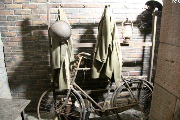 Bicycle, heavy jacket & helmet that might have been brought into air raid shelter during bombing raid at Cardiff Castle. Cardiff, Wales.