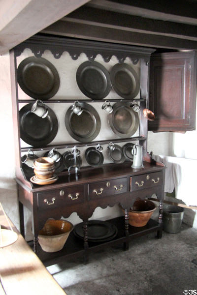 Wood kitchen cupboard with pewter plates on display in Kennixton Farmhouse at St Fagans National Museum of History. Cardiff, Wales.