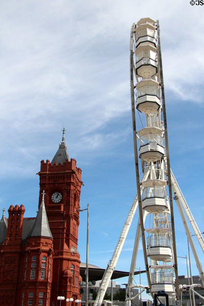 Side view of Ferris wheel & red terracotta Pierhead building at Cardiff Bay. Cardiff, Wales.