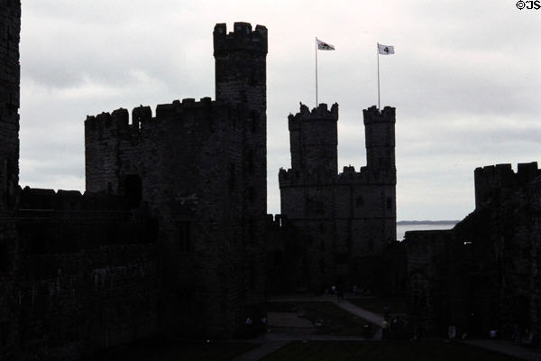 The walls & towers of Caernarfon Castle profiled against the sky. Caernarfon, Wales.