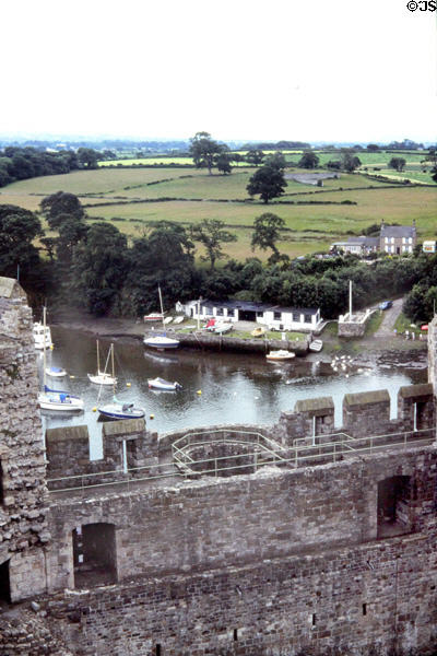 Pleasure boats on River Seiont with green fields beyond as seen from Castle. Caernarfon, Wales.