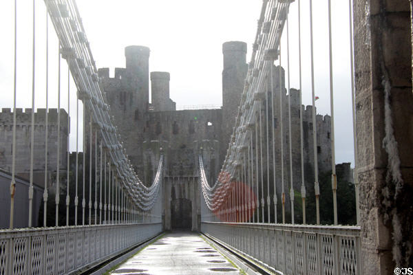 Thomas Telford's suspension bridge (1822-26), one of the first road suspension bridges in the world, was designed to fit in with the architecture of Conwy Castle, the bridge towers being smaller versions of the castle towers. Conwy, Wales.