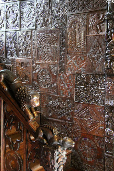 Carved wood paneling on staircase wall with lion chasing squirrel down railing at Plas Newydd. Llangollen, Wales.