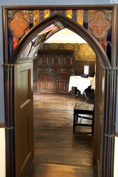 Gothic Revival arched carved wood doorway with stained glass insets at Plas Newydd. Llangollen, Wales.
