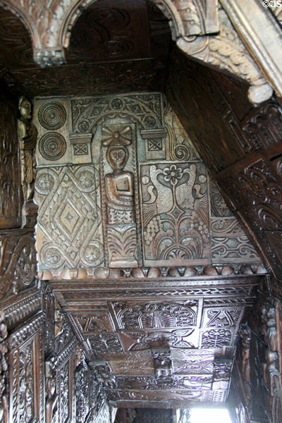 Panels with elaborate carved wood designs covering ceiling & walls on staircase at Plas Newydd. Llangollen, Wales.