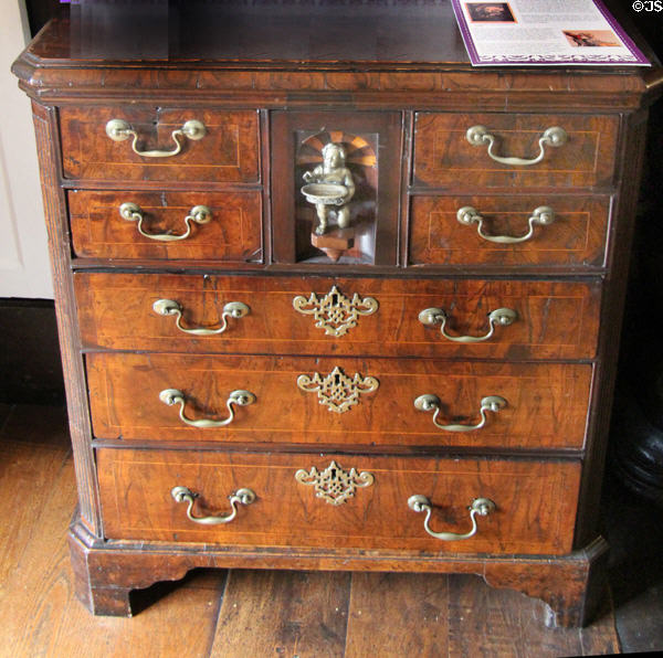 Norfolk chest of drawers (likely late 18thC) with brass handles, decorative work & display niche at Plas Newydd. Llangollen, Wales.