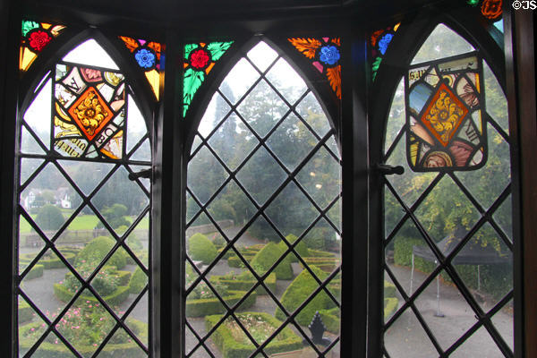 Window with stained glass panels looking out to garden at Plas Newydd. Llangollen, Wales.