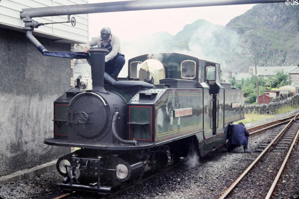 Putting water into Blaenau Ffestiniog Railway steam engine sitting on narrow gauge track. Blaenau Ffestiniog, Wales.