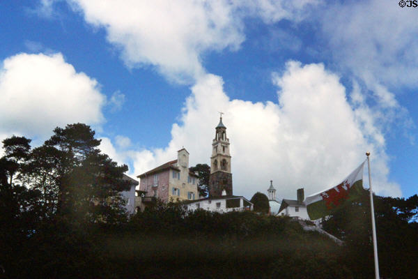 View of Portmeirion Village atop hill with Welsh flag in foreground. Gwynedd, Wales.