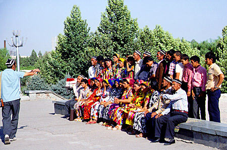 Visitors lined up for a photo in front of Registan mosque in Samarkand. Uzbekistan.