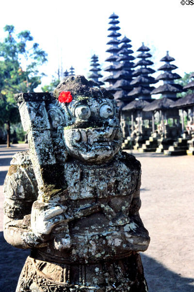 Carved guardian with flower offering of Pura Taman Ayun temple at Mengwi. Bali, Indonesia.
