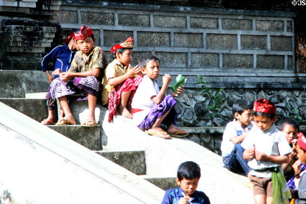 Young boys sit on temple steps. Bali, Indonesia.