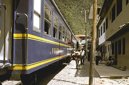 Train running down main street of Aguas Calientes. Peru.