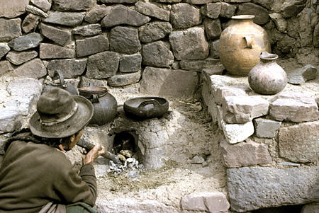 Dung fire started with blowpipe on farm near Puno. Peru.