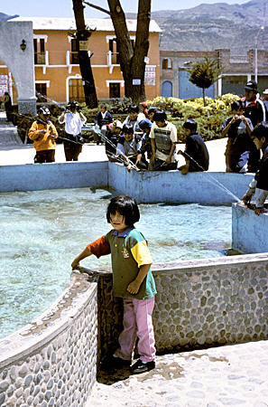 Children playing at fountain in Plaza de Armas in town of Chivay. Peru.