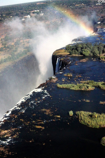 Rainbow forms as water falls at Victoria Falls. Zimbabwe.