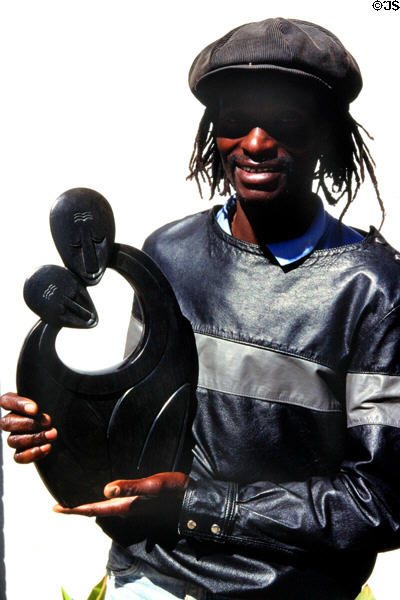 Artist poses with his modern sculpture which is typical of Harare. Zimbabwe.