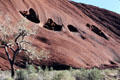 Four caves aligned on side of Uluru. Australia.