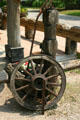 Wagon wheel leaning against antique well pump. Kleinburg, ON.