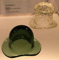 Molded glass top hat attrib. Burlington Glass Works of Hamilton, ON beside glass bowler hat container from England at Montreal Museum of Fine Arts. Montreal, QC.