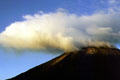 Volcano letting off smoke with clouds forming above at Arenal. Costa Rica.