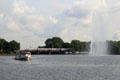 Passenger train crossing with Lake Alster fountain in foreground. Hamburg, Germany.