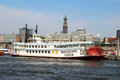 Mississippi Queen paddle wheel tour boat on Elbe River with St. Michael's Church in background. Hamburg, Germany.