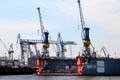 Elbe River shipyard with floating drydock & cranes. Hamburg, Germany.