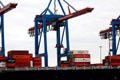 Cranes moving cargo on container ship at container port. Hamburg, Germany.