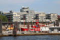 Gray Hamburg New City with round windows over docked red light ship. Hamburg, Germany